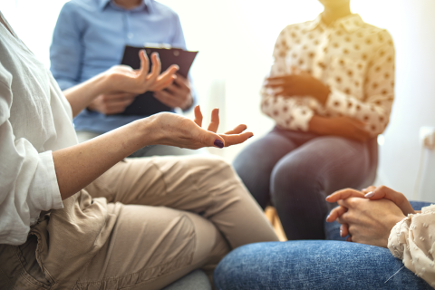 vier Menschen sitzen im Kreis und unterhalten sich